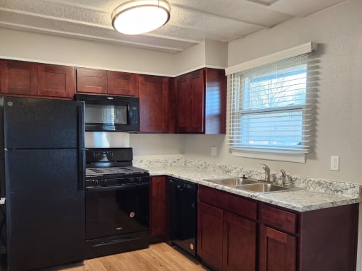 a kitchen with black appliances and granite counter tops