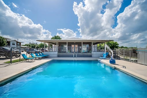A large swimming pool with a building in the background.