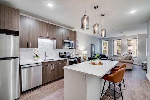 A modern kitchen with a white island and stainless steel appliances.
