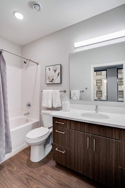 A white toilet sits in a bathroom with a brown cabinet.