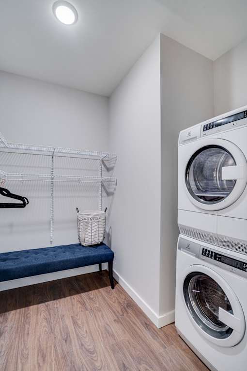 A laundry room with a washer and dryer stacked on top of each other.
