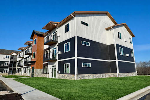 A modern apartment building with a mix of white, black, and brown exterior colors.