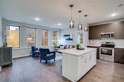 A modern kitchen with a white island and wooden floors.