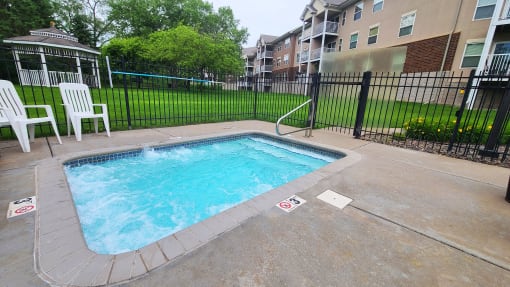 a swimming pool in a fenced in area of an apartment building