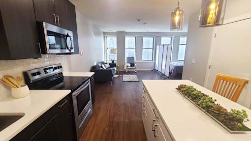 A kitchen with black cabinets and a white countertop.