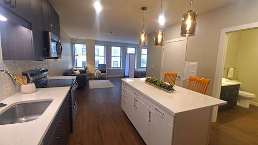 A kitchen with white countertops and wooden cabinets.