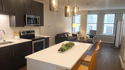 A kitchen with a white counter top and a plant on it.