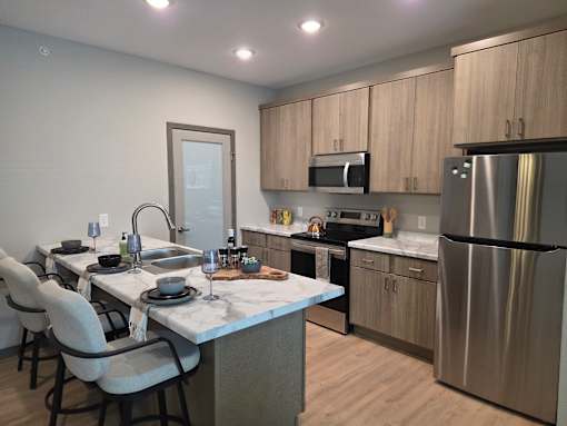A modern kitchen with a dining table set for four.