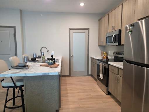 A kitchen with a table and chairs.