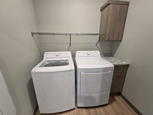 Two white front loading washing machines in a laundry room.
