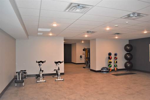 A gym with exercise equipment and a mirror.