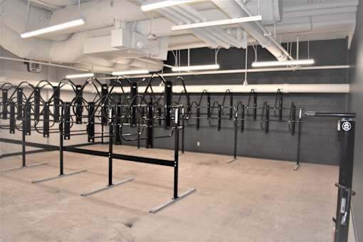 A gym with a row of black weight racks.