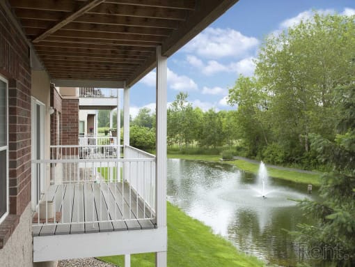 a porch overlooking a pond with a fountain
