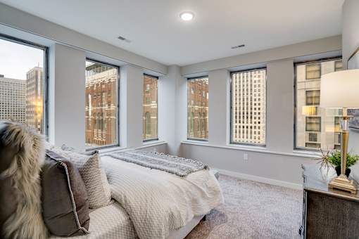 A bedroom with a large bed and a view of the city.