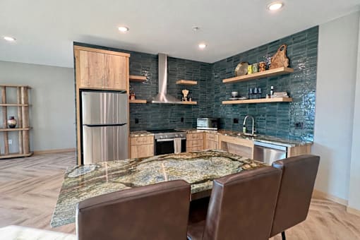 A kitchen with a large island and a refrigerator.