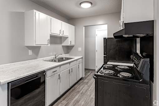 A kitchen with white cabinets and a black stove top oven.
