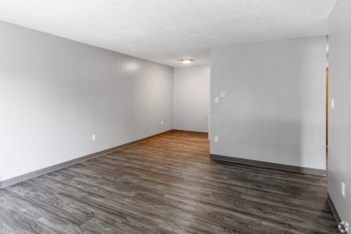 A room with wooden flooring and white walls.