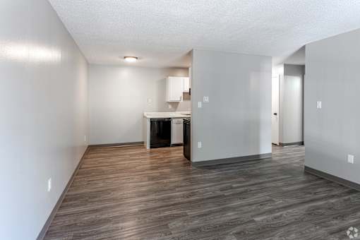 A room with wooden flooring and white walls.