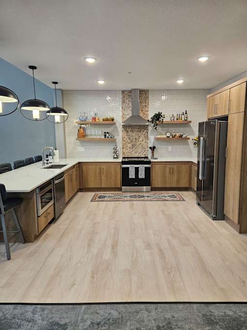 A clubhouse kitchen with wooden floors and a central island.