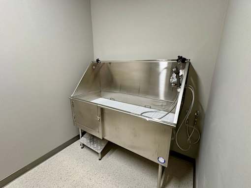 A stainless steel sink in a room with white walls.