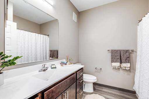 A bathroom with a white countertop and a white toilet.