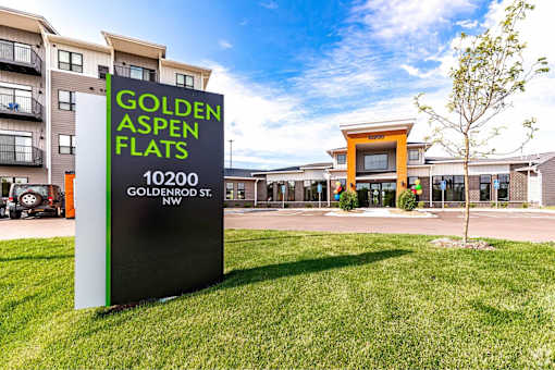 A sign for Golden Aspen Flats is in the foreground of a grassy area.