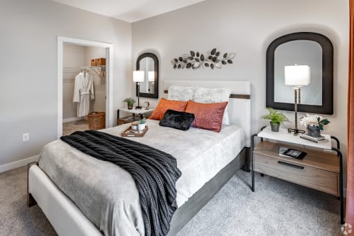 a bedroom with a bed and a mirror on the wall