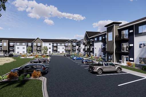 A row of modern townhouses with cars parked in front.