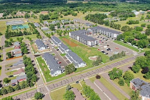 A bird's eye view of a residential area with houses, roads, and a large building.