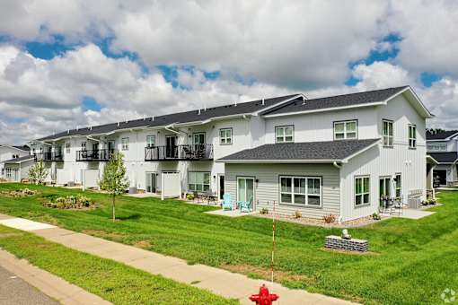 A row of houses with a red fire hydrant in front of the first house.