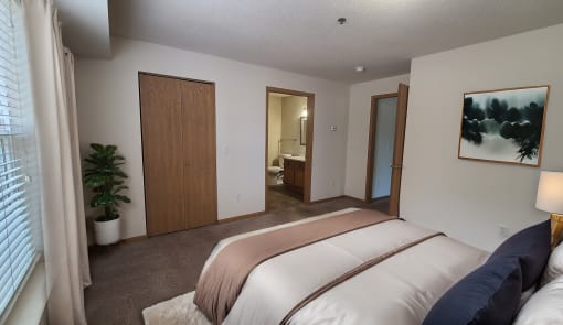 a bedroom with a bed and a closet and a bathroom