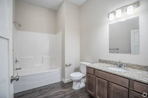 A bathroom with a toilet, sink, and bathtub.