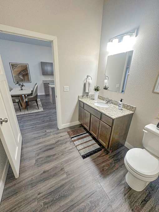 A bathroom with a white toilet, sink, and mirror.