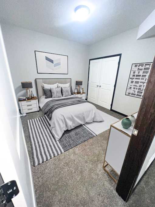 A bedroom with a bed, nightstands, and a dresser.