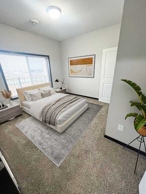 A bedroom with a large bed and a painting on the wall.