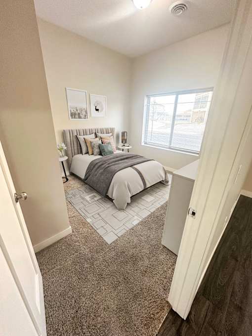 A bedroom with a bed, nightstand, and two pictures on the wall.