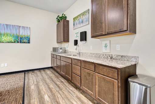 A kitchen with wooden cabinets and a marble countertop.