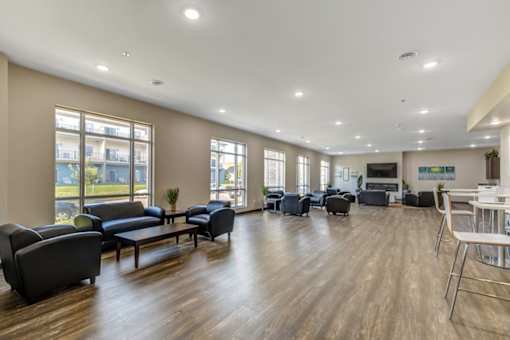 A spacious living room with a variety of seating options and a television.
