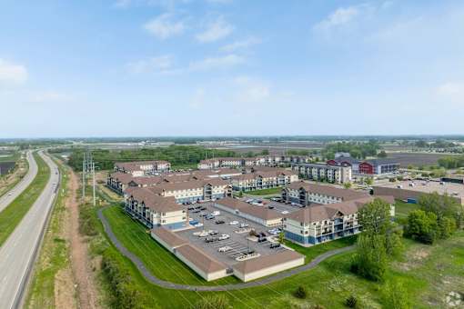 A large building complex with a parking lot in front of it.