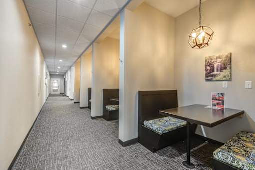 A long hallway with a table and chairs at the end.