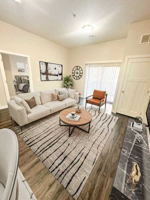 A living room with a white couch, a coffee table, and a rug.