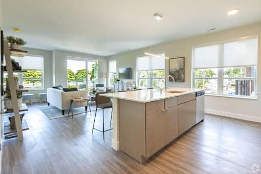 A modern kitchen with a large island and a dining area.