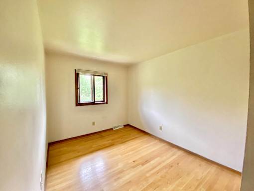 A room with a window and wooden floors at Root River Apartments, Greendale, Wisconsin