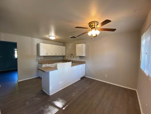 A room with a ceiling fan and a counter at Root River Apartments, Greendale, 53129