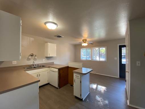 A kitchen with white cabinets and a white dishwasher at Root River Apartments, Greendale, WI, 53129