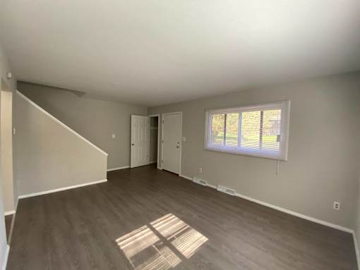 A room with a window and a door is shown at Root River Apartments, Greendale