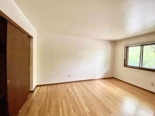 A room with wooden flooring and a window at Root River Apartments, Greendale, Wisconsin