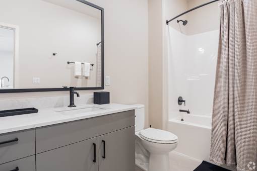 A bathroom with a white toilet and a shower with a curtain at Bloom, Monona