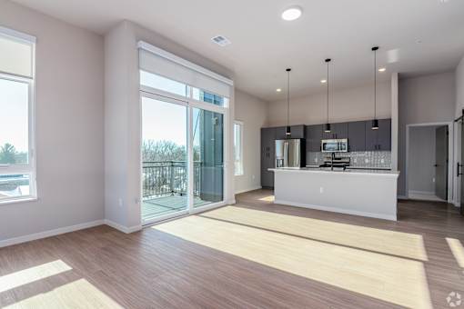 A modern kitchen with a bar area and sliding glass doors at Bloom, Monona, WI, 53716
