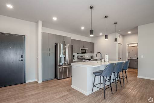A modern kitchen with a bar area and stools at Bloom, Wisconsin, 53716